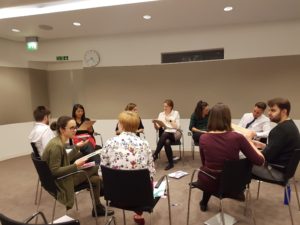 10 people sat in chairs in a circle, deep in conversation in pairs, at an Academy of Medical Sciences workshop