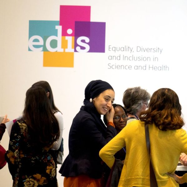 A group of people talking underneath the EDIS logo